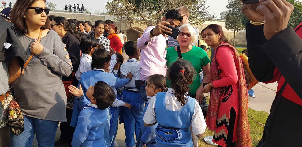       Group of people including school children in uniform.
  