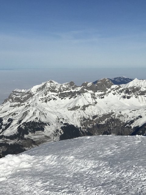 Snowy mountain range view under a blue sky.