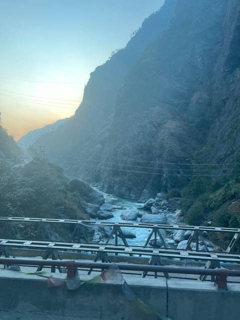 Scenic view of a river and mountains intersected by a bridge.