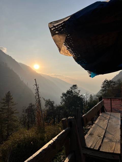 Sunrise over a mountain range viewed from a wooden structure.