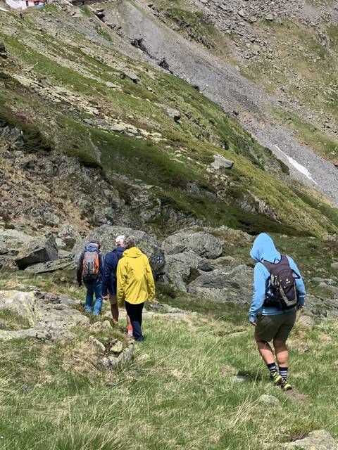       Hikers climbing a mountain in rough terrain.
  