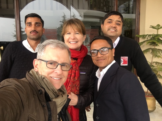       Group selfie with people indoors.
  