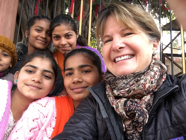       Group selfie with smiling people, some children.
  