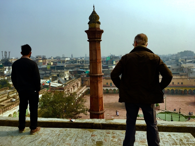       Two people overlooking a city from high vantage point.
  