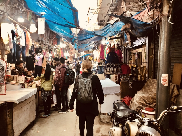       Person walking through a bustling market street.
  