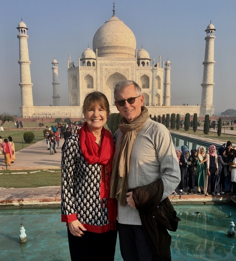      Smiling couple with the Taj Mahal in the background.
  