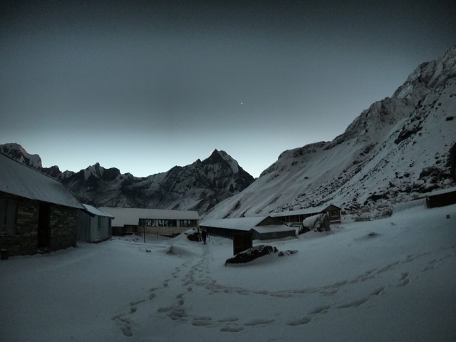       Snowy mountain landscape with a small settlement.
  