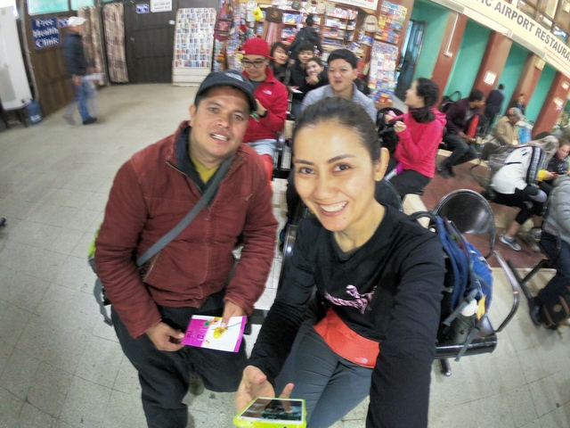       Two people in a busy indoor setting.
  