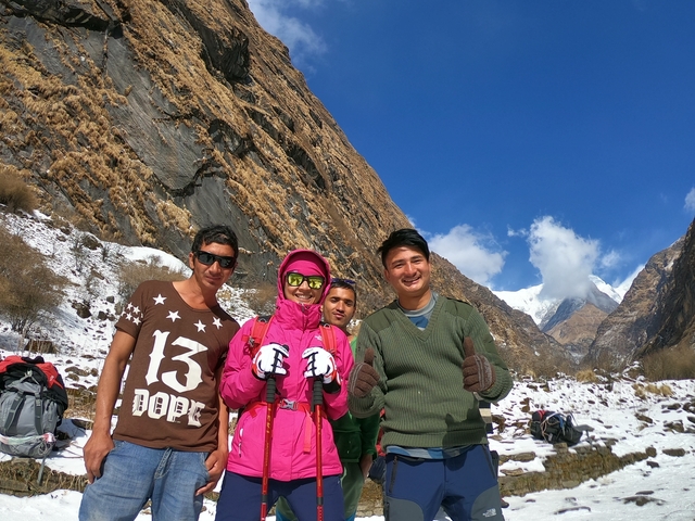       Group of hikers posing with a snowy backdrop.
  