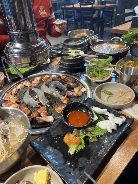       Traditional Korean barbecue setting with various dishes.
  