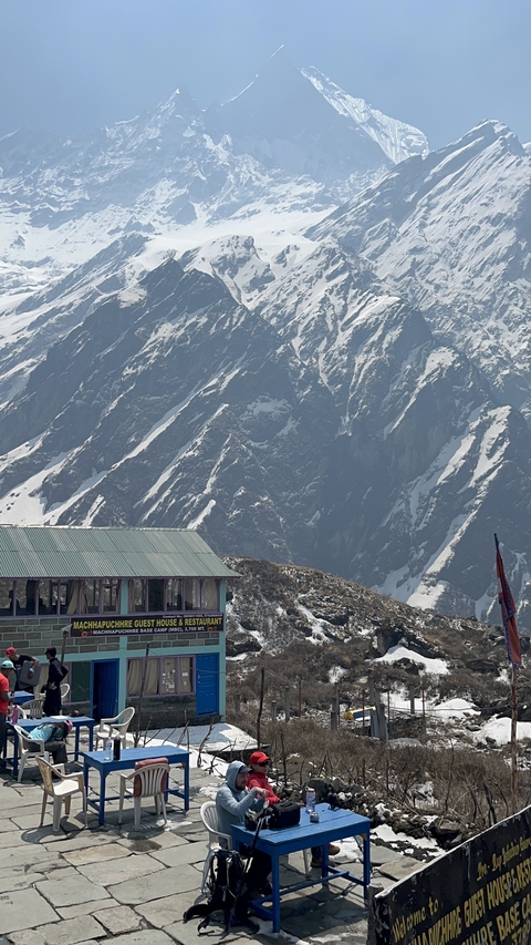 Mountain cabin with backdrop of steep rocky mountains.