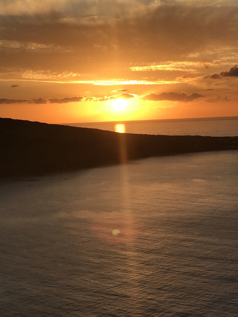 Sunset over the ocean with a silhouetted mountain