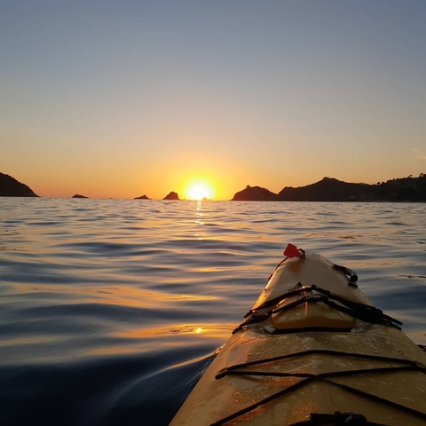 Kayak on the water at sunset with distant islands