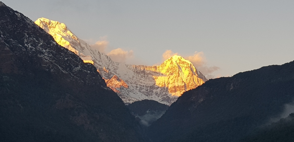       Snow-covered mountain with golden light at sunrise.
  