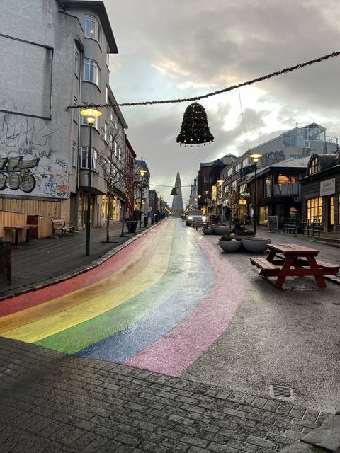 Colorful street with rainbow painted on the pavement.