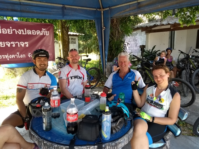 Group of cyclists taking a break at a rest stop.