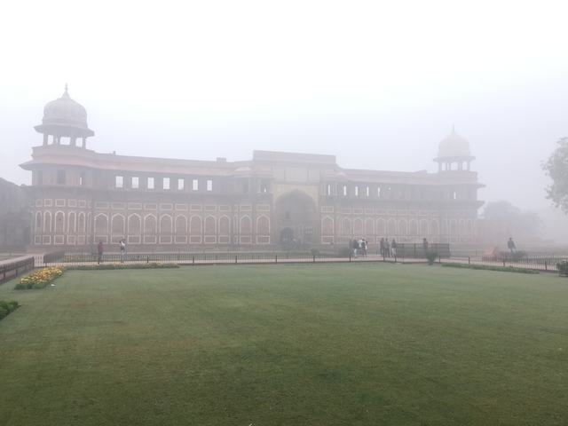       Red sandstone gate with fog in the background.
  