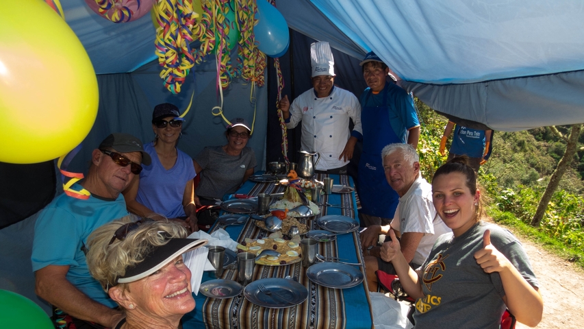       Group inside a tent decorated for a celebration.
  