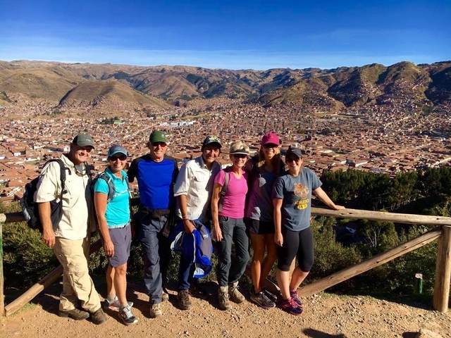       Group of people overlooking a city from a balcony.
  