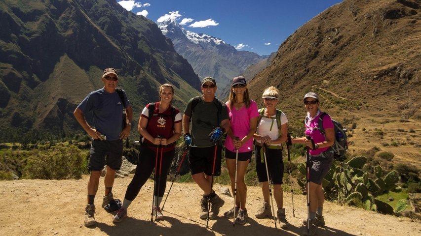       Group of hikers with a mountainous background.
  