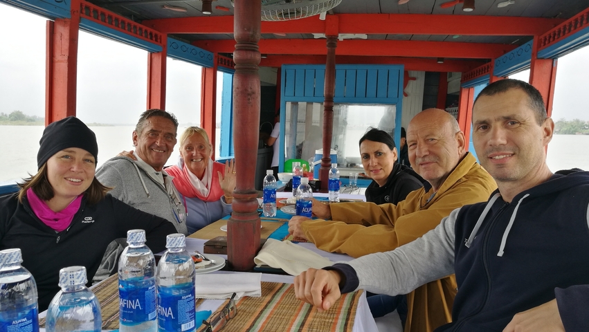 A group of people seated at a table on a boat.