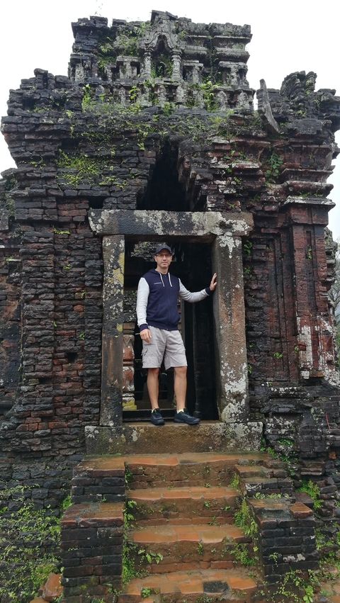 A person standing in front of an ancient stone structure.