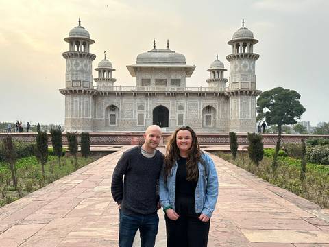 Tourists in front of a beautifully detailed Mughal architecture.