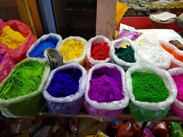       Vibrantly colored powders displayed in bags.
  