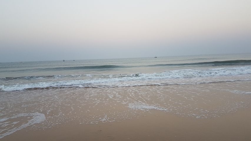 Calm ocean with gentle waves at sunset.