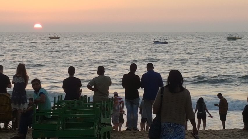 People watching the sunset by the ocean.