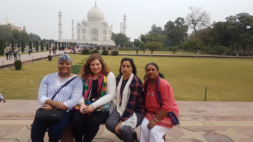 Group of people posing in front of the Taj Mahal.