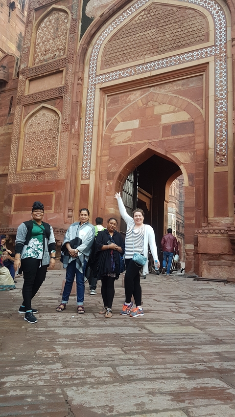       Group posing at an ornate historical entrance.
  