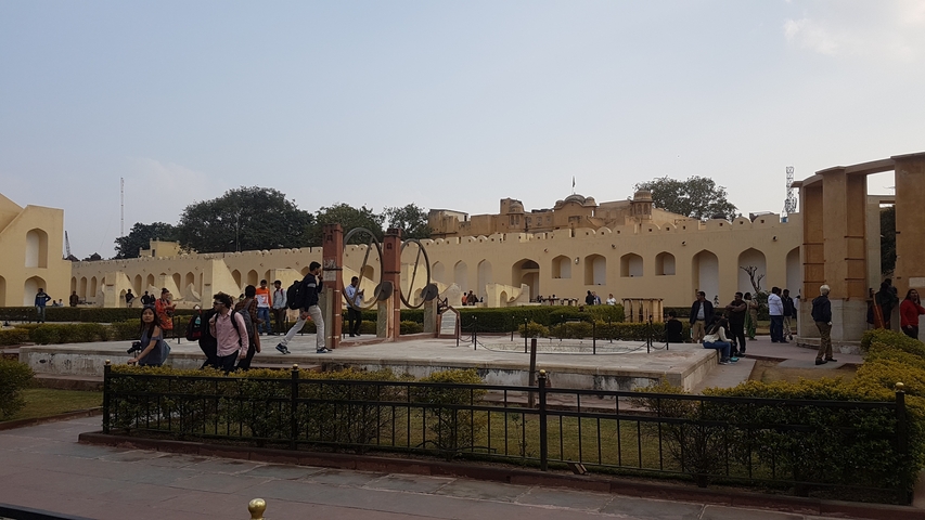       Visitors exploring a historical site with gardens.
  