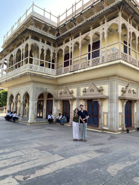       Couple standing in front of a historical building with intricate designs.
  