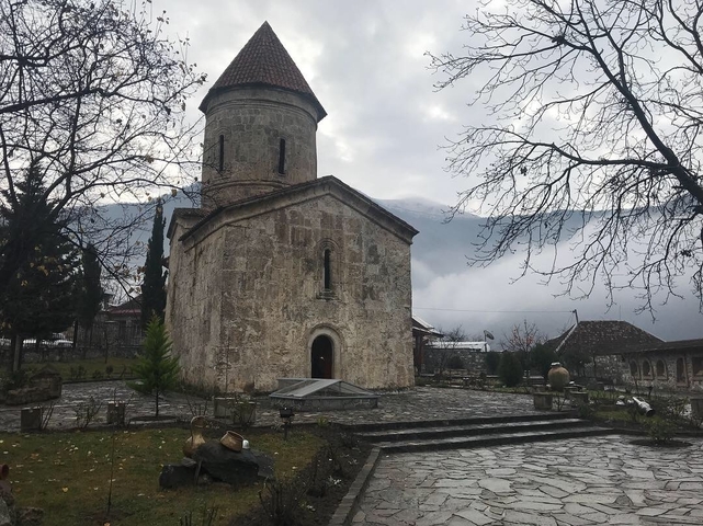       Stone church with mountains in the background.
  