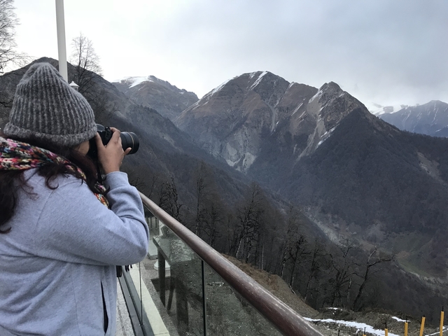 Person taking a photograph of mountains.