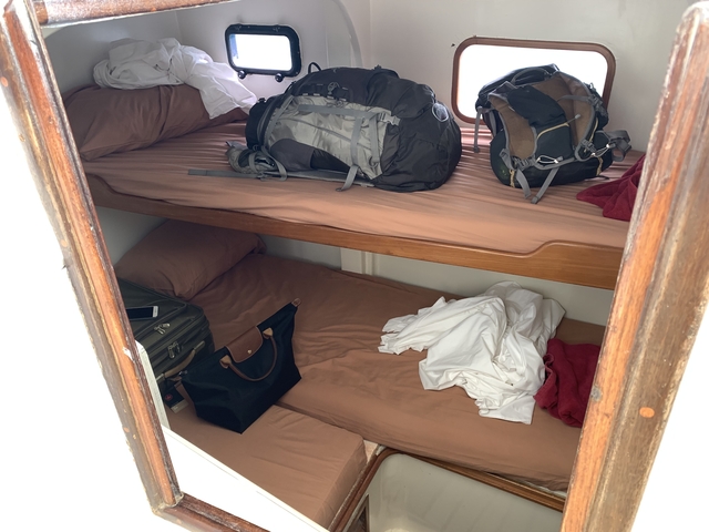 Compact bedroom with bunk beds and backpacks.