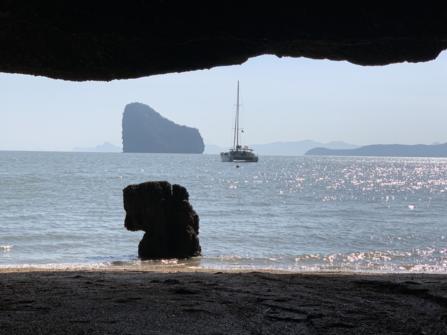 Scenic view of a sailboat on the sea near limestone cliffs.