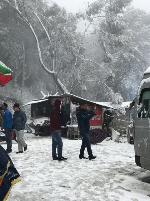 People in a snowy setting with a makeshift stall.