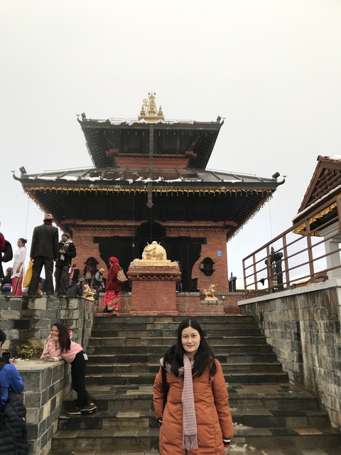 Temple with people visiting and light snow cover.
