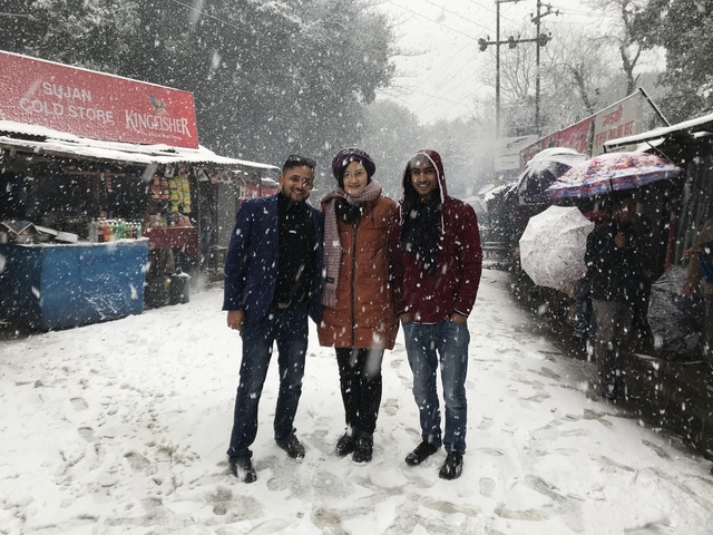 Group of people posing in a snowy market setting.