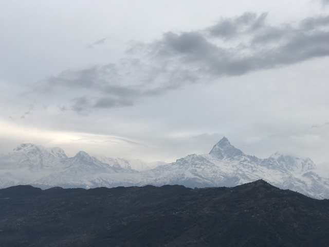       Snow-capped mountains with cloudy sky.
  
