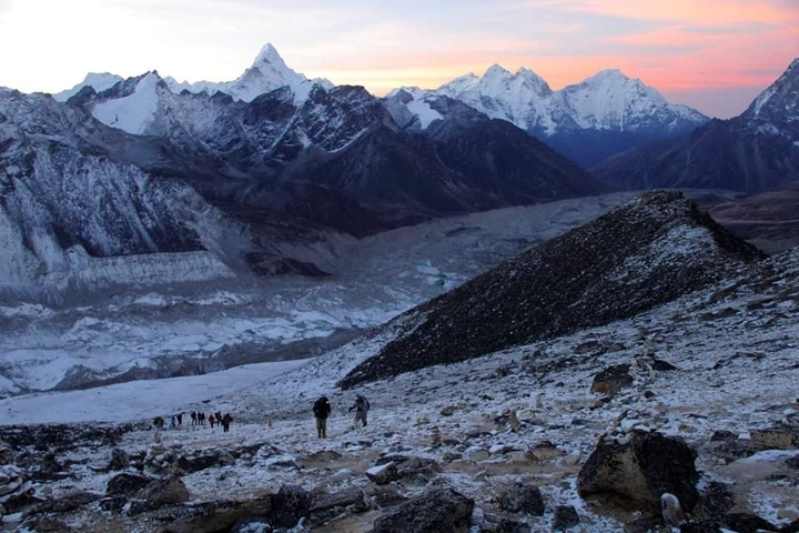 Mountainous landscape with snowy peaks during twilight.