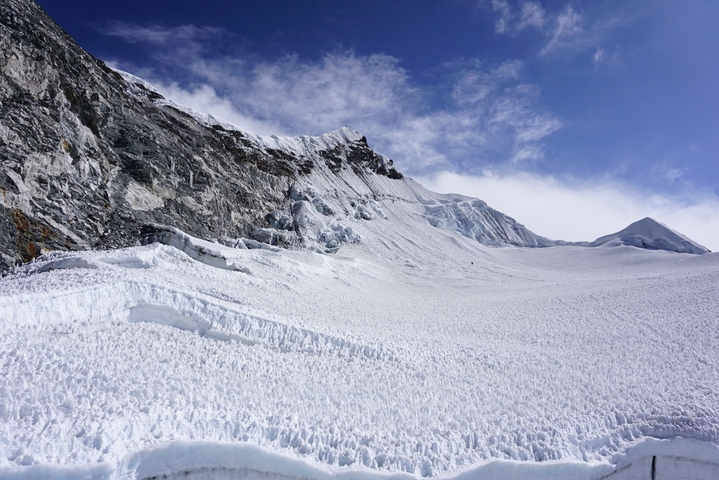       A vast expanse of snow-covered mountains under a blue sky.
  