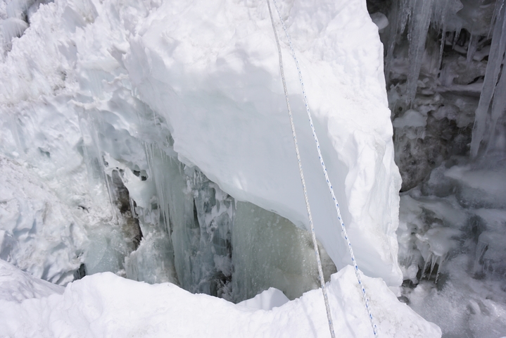 A crevasse in a snowy mountain with safety ropes.