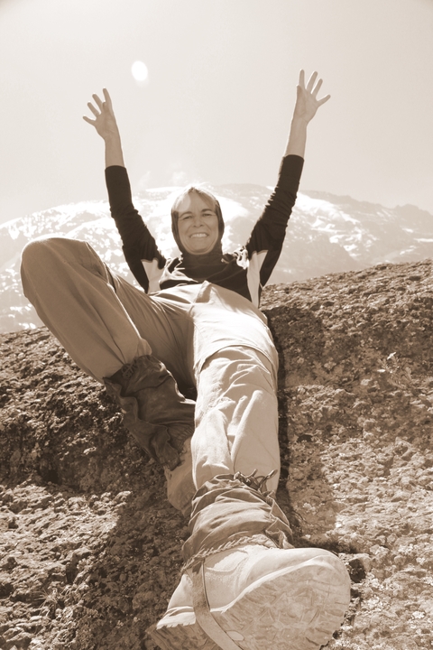       A sepia-toned photo of a person reclining on a rock.
  