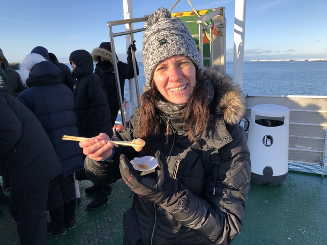      Person enjoying seafood on a boat deck
  