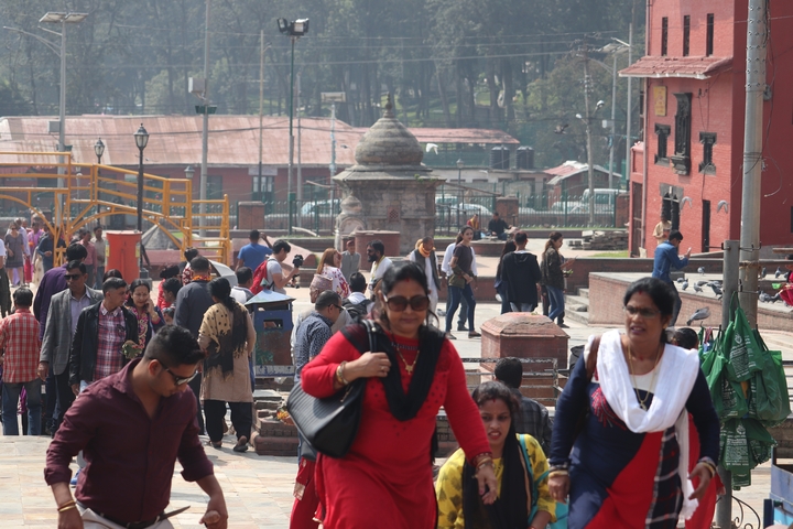       Crowded street scene with people walking and buildings
  