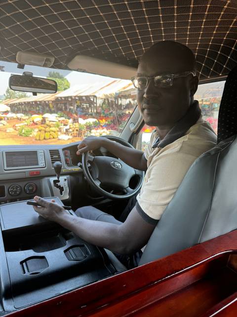       A driver sitting in the driver's seat of a vehicle.
  