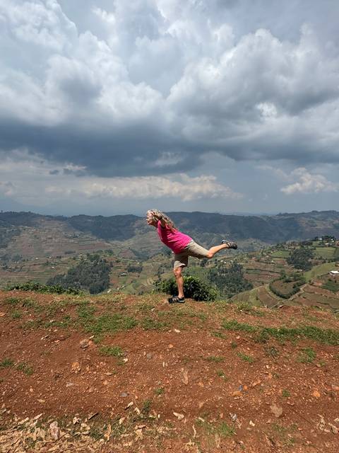       A person jumping in the air with a valley in the background.
  